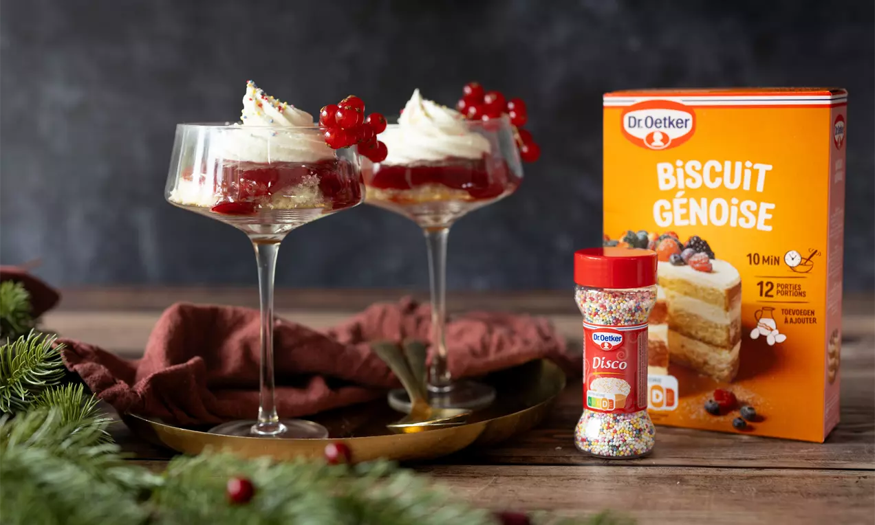 Mini trifle de Noël avec biscuit léger, confiture de framboise et crème fouettée dans des verres élégants